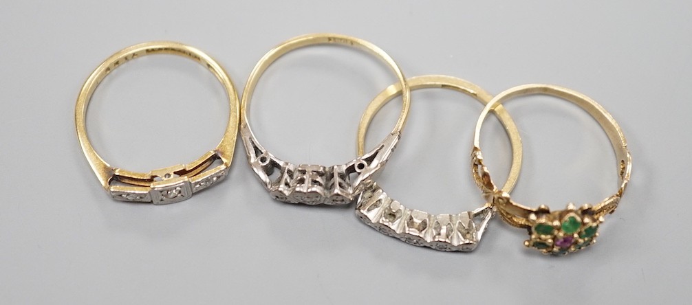 Three early 20th century 18ct and diamond chip set rings and a yellow metal, garnet and emerald cluster set flower head ring, gross weight 7.7 grams.